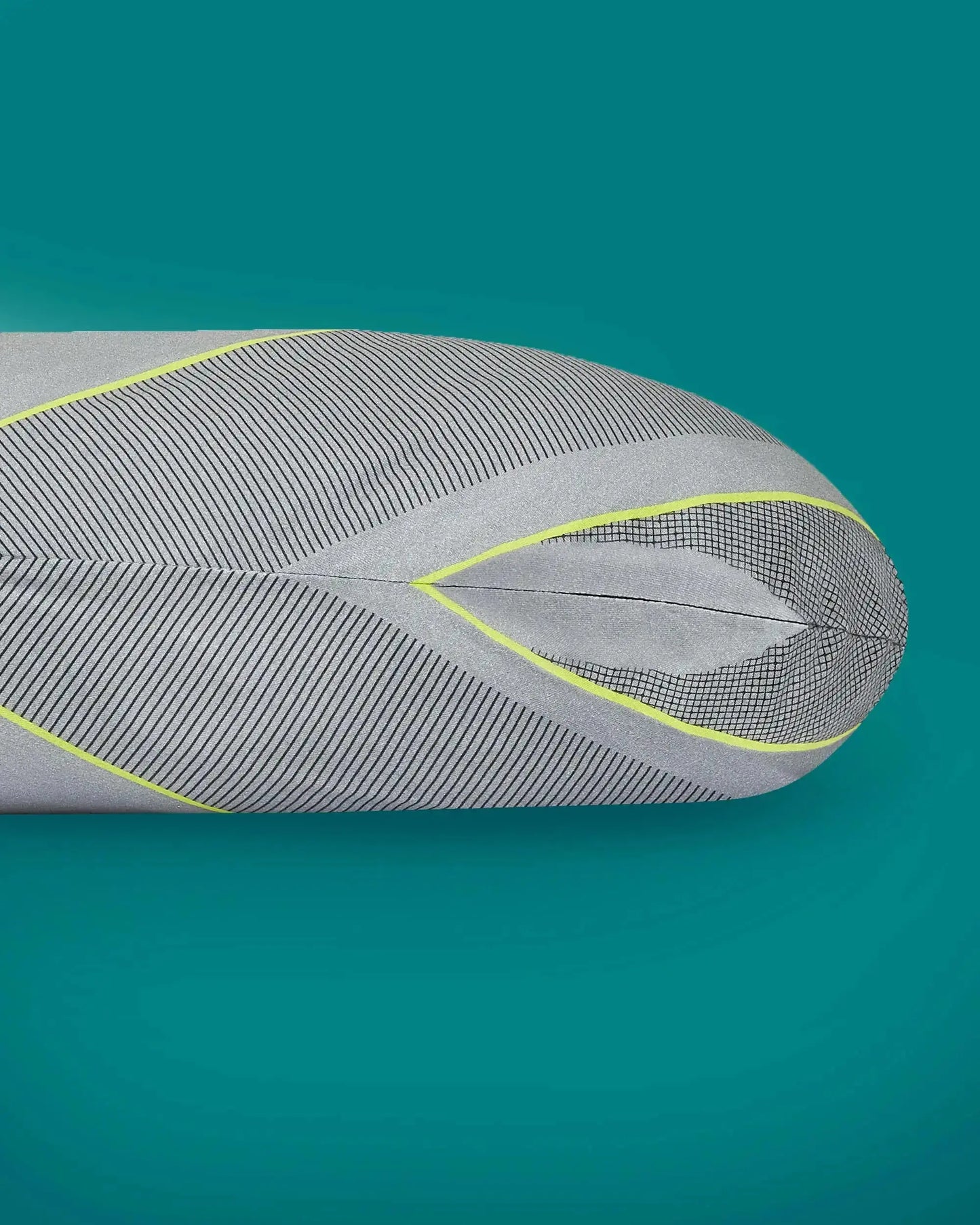 Ergonomic grey pillow with black lines and yellow accents on teal background