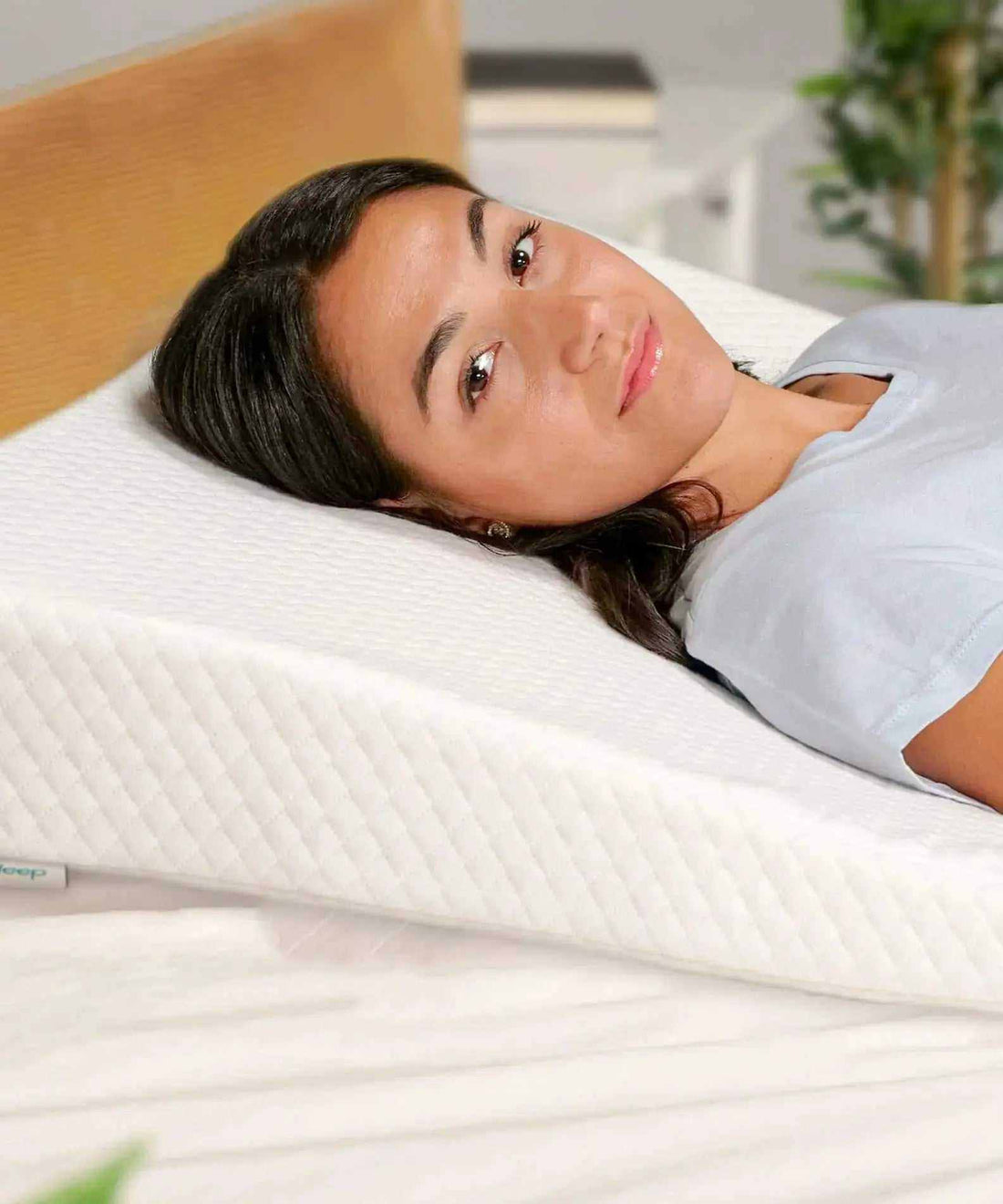 Woman sleeping on white acid reflux pillow wedge for comfort and support