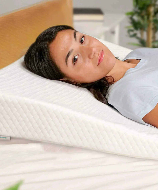 Woman sleeping on white acid reflux pillow wedge for comfort and support
