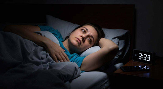 Person lying awake in bed looking anxious struggling with sleep at night