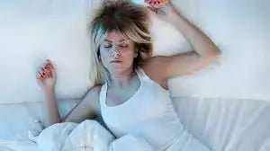 person sleeping comfortably in a cool, dark bedroom during a heatwave
