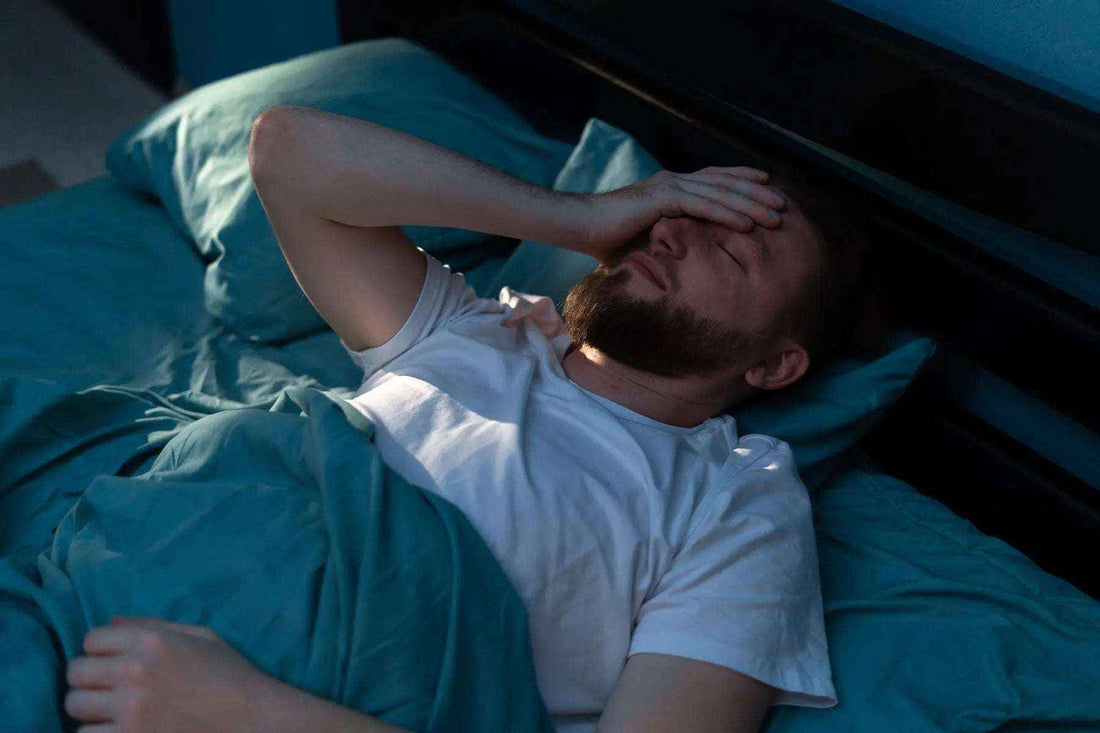 Woman lying awake in bed at night struggling with insomnia causes and sleep deprivation
