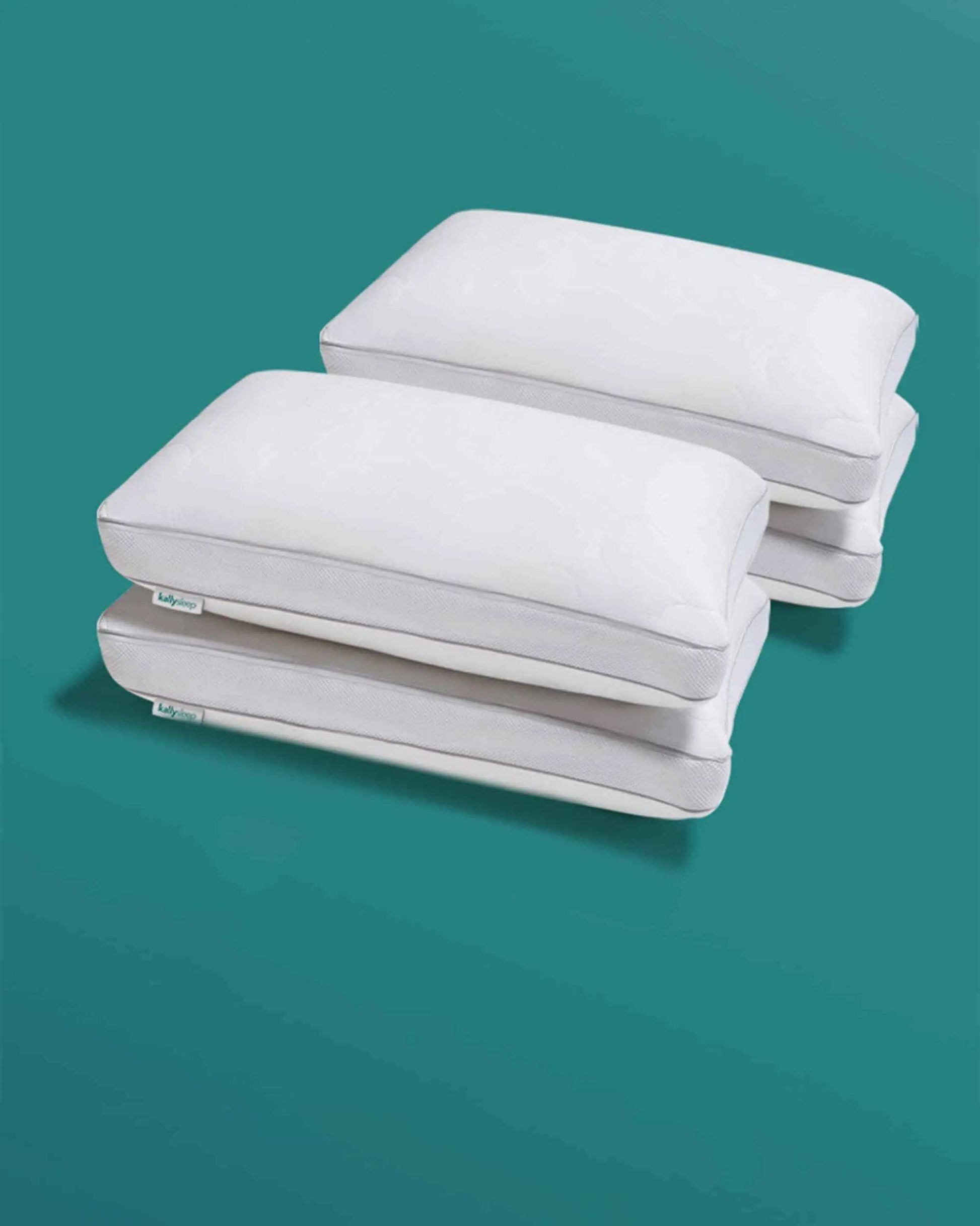 Stack of four white adjustable ergonomic pillows on a teal background