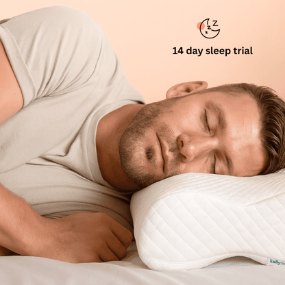 Man sleeping on a pillow with a '14 day sleep trial' offer displayed above.